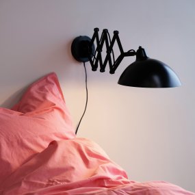 Futura 60cm Schwarz wandlampe Von Dyberg Larsen - Es besteht aus Metall mit einer schwarzen Außenseite und einer weißen Innenseite und erzeugt einen minimalistischen Look.