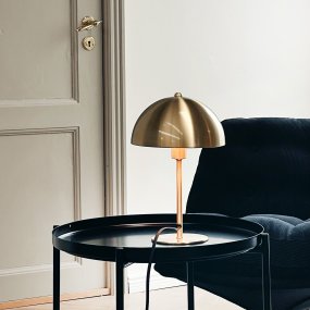 Lyon 30cm Messing tischlampe Von Dyberg Larsen - Der halbrunde Schirm verleiht einen modernen Touch und sorgt für eine angenehme und gleichmäßige Lichtverteilung, ideal sowohl für die Arbeits- als auch für die Stimmungsbeleuchtung.