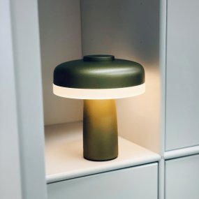 Porter 16cm Metallic-Grün tragbare Von Dyberg Larsen - Die wiederaufladbare LED-Tischleuchte Porter ist eine moderne und funktionale Leuchte mit einzigartigem Design, bei dem das Licht vom Rand kommt und so für ein angenehmes und gleichmäßiges Licht sorgt.