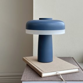 Porter 16cm Indigo tragbare Von Dyberg Larsen - Die wiederaufladbare LED-Tischleuchte Porter ist eine moderne und funktionale Leuchte mit einzigartigem Design, bei dem das Licht vom Rand kommt und so für ein angenehmes und gleichmäßiges Licht sorgt.