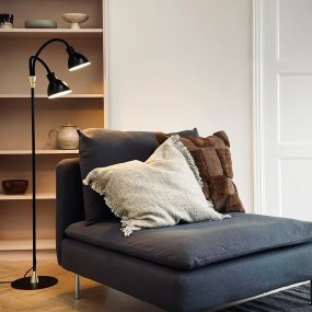 Lilje Schwarz stehlampe Von Dyberg Larsen - Lily golvlampa i svart och m&auml;ssing kombinerar modern design med flexibilitet och funktionalitet.