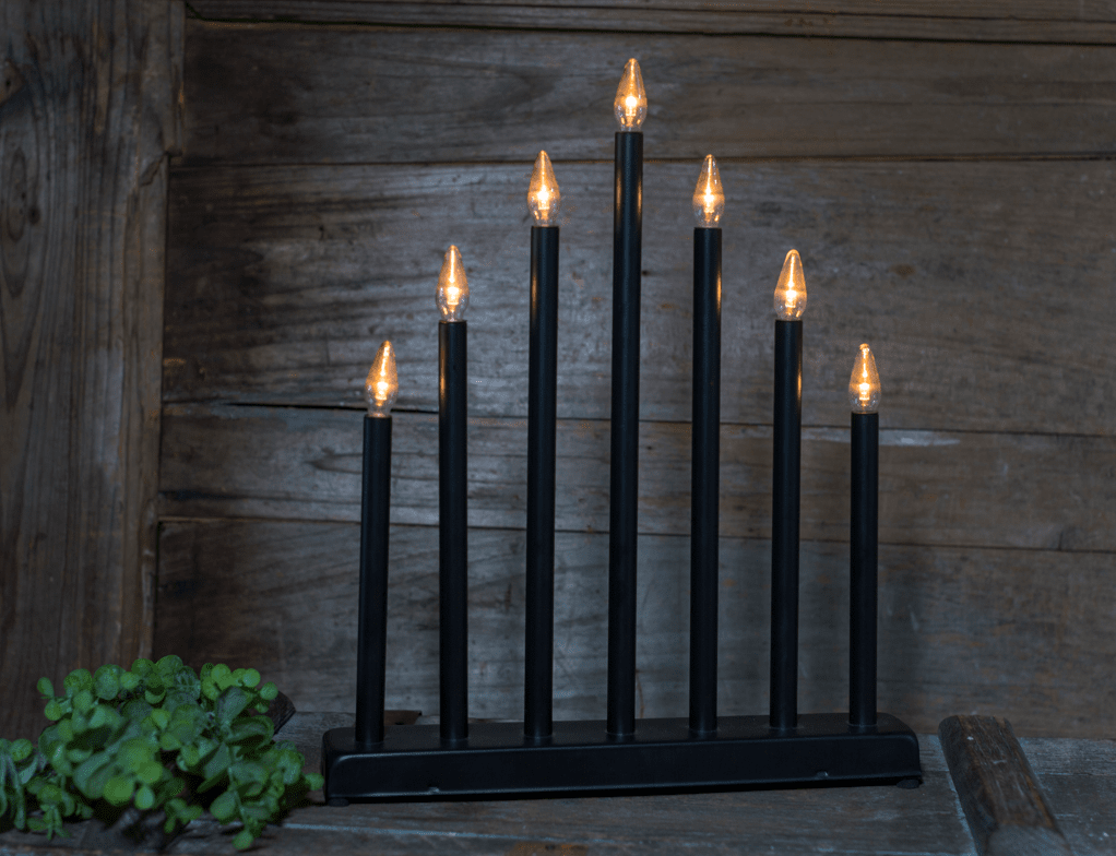 Fire Schwarz Von Pixie Design - Der Fire Batterie-Kerzenst&auml;nder mit 7 Armen in Schwarz ist ein moderner und stilvoller Kerzenst&auml;nder, der ein warmes und angenehmes Licht verbreitet.
