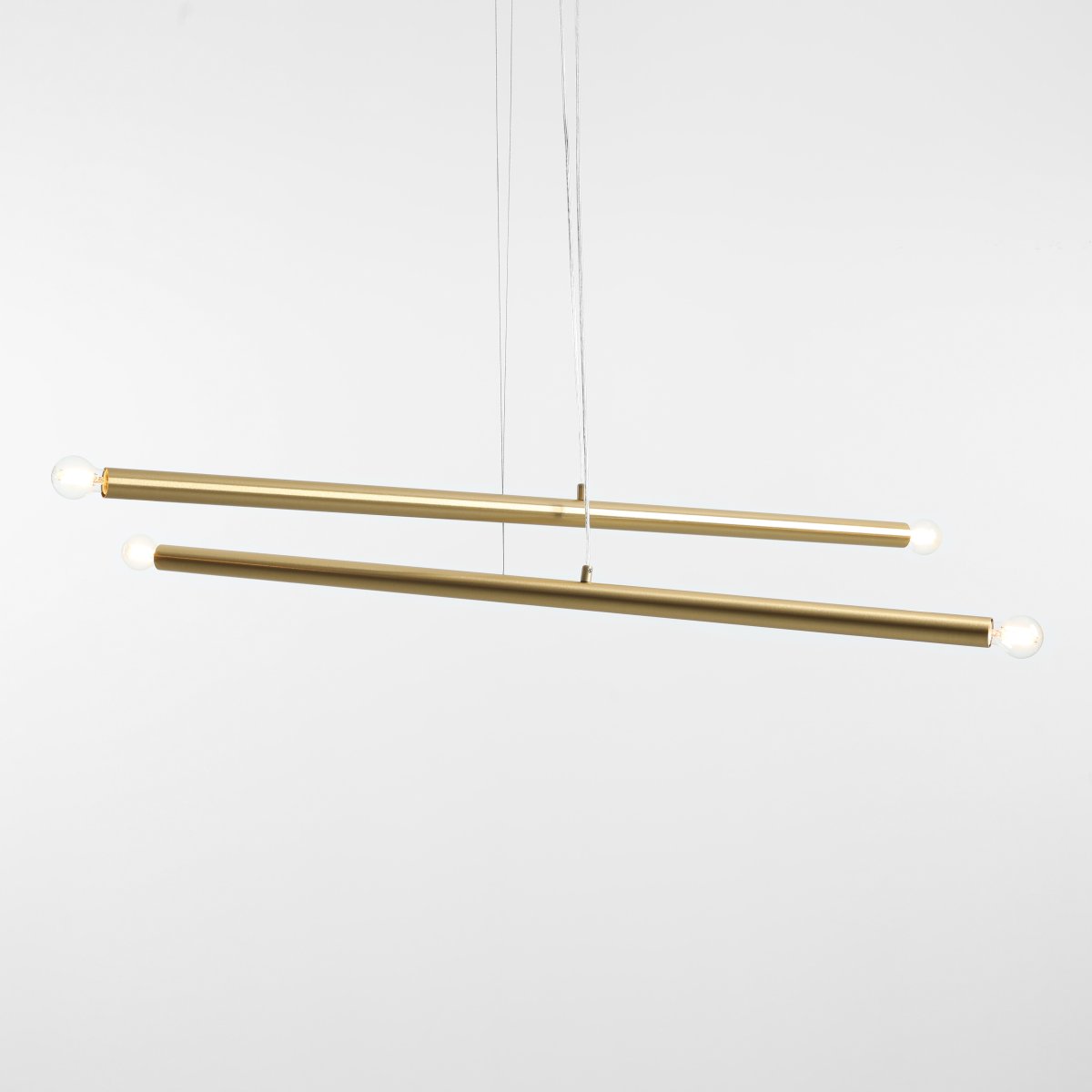 Tubo 4 100cm Messing hängelampe Von Artera - Die Leuchte besteht aus zwei schmalen Metallrohren in elegantem Messing-Finish, die in unterschiedlichen Winkeln angeordnet sind und so eine dynamische und luftige Optik erzeugen.