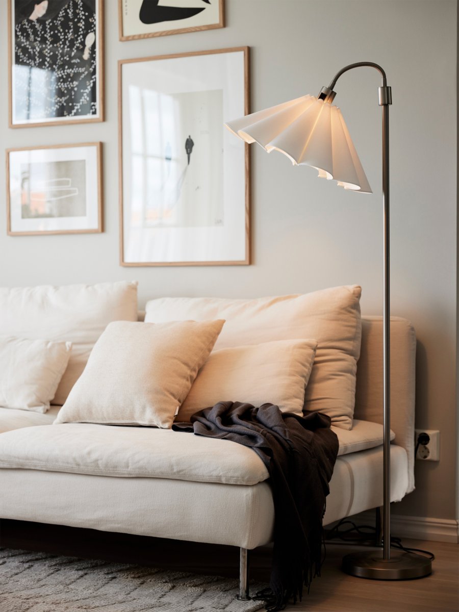 Amy Flex Silber stehlampe Von PR Home - Die Lampe hat ein silberfarbenes Metallgestell mit einem verstellbaren Arm und einem praktischen Ein-/Ausschalter am Fuß.
