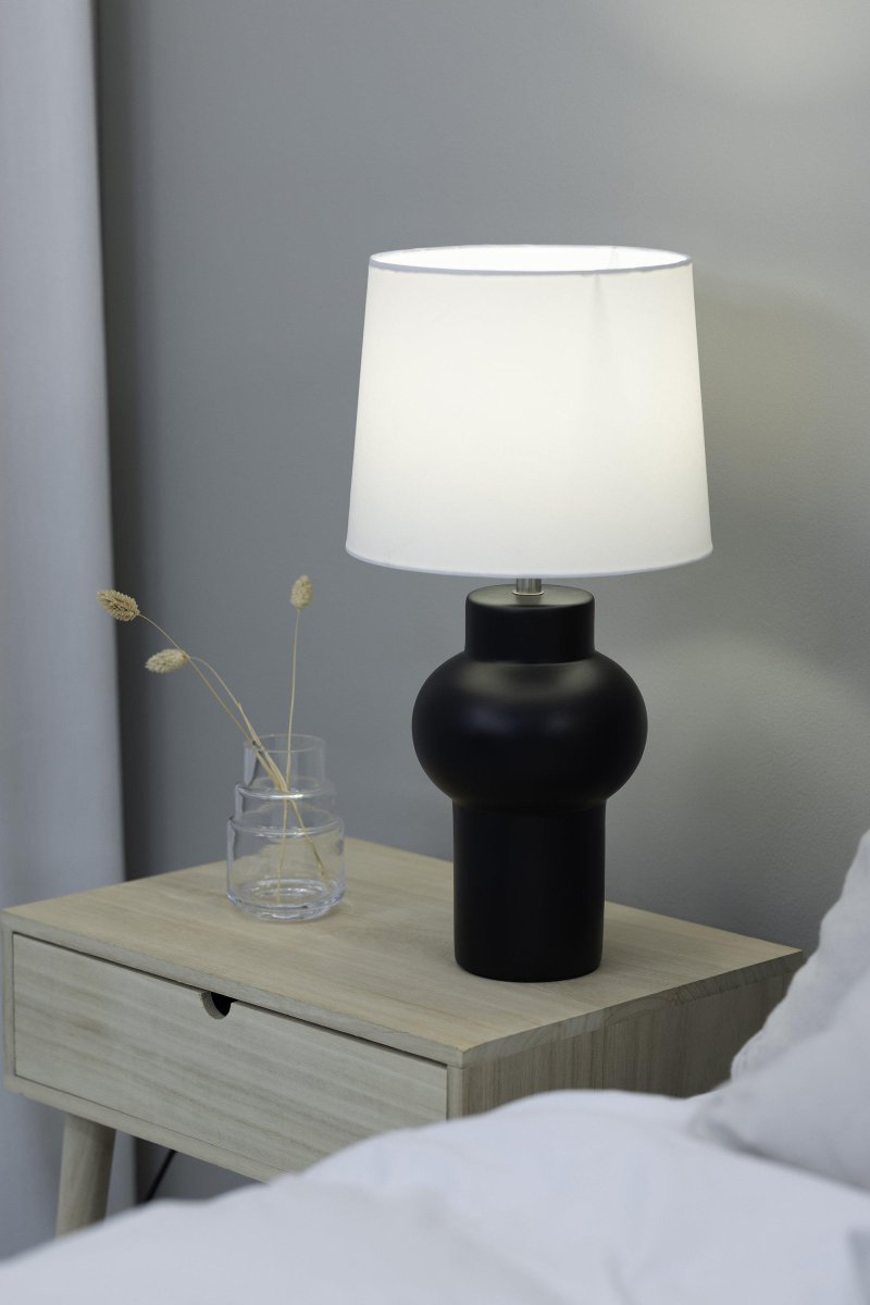 Shape 46cm Schwarz tischlampe Von Markslöjd - Die Shape-Tischlampe ist eine stilvolle schwarze Lampe mit einem sch&ouml;nen Keramiksockel und einem wei&szlig;en Textilschirm, der ein sanftes Licht erzeugt.