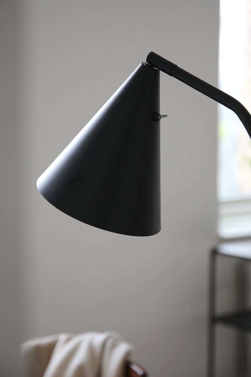 Funil Schwarz stehlampe Von Markslöjd - Die Lampe ist aus schwarz lackiertem Metall gefertigt und verfügt über einen dekorativen, kegelförmigen Lampenkopf, der gedreht und verstellbar ist.