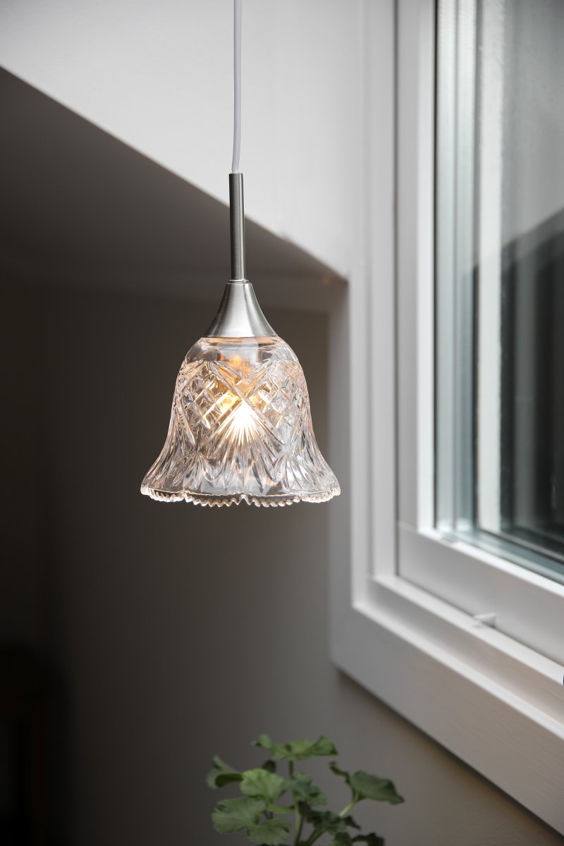 Luna Ø14 Transparent/Stahl fensterlampe Von Markslöjd - Fensterleuchte aus transparentem Glas mit feinen Details in satiniertem Nickel-Finish und einer dekorativen, sanft geschwungenen Form am unteren Ende &ndash; ein romantisches Design, das eine warme und einladende Atmosph&auml;re am Fenster oder in einer kleinen Ecke schafft.