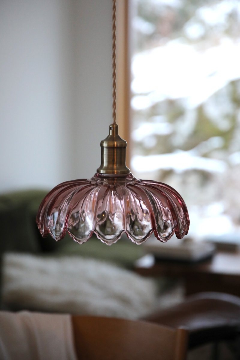 Kurage Ø26 Rosa hängelampe Von Markslöjd - Die Leuchte hat eine Fassung in Messingoptik und ein dekoratives, beigefarbenes Textilkabel, das zu einer runden Metallhalterung in derselben Messingoptik f&uuml;hrt.