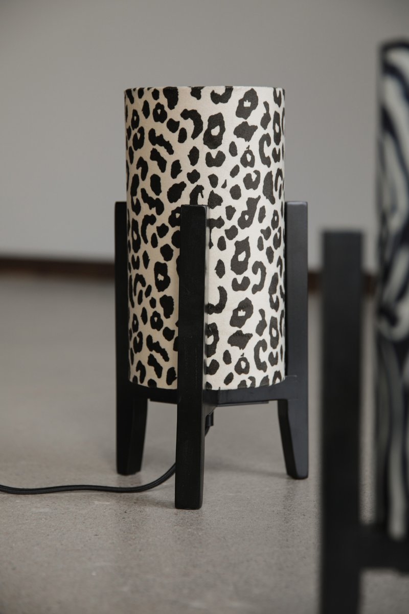 Eruca 34cm Leopard tischlampe Von Markslöjd - Der Lampenfu&szlig; aus schwarzem Holz wird mit einem zylindrischen Textilschirm in cremewei&szlig;em und braunem Leopardenmuster kombiniert, was der Lampe einen trendigen und individuellen Charakter verleiht.