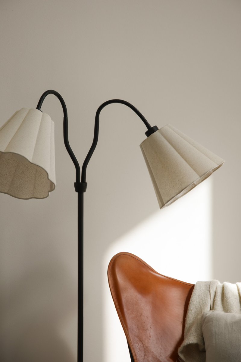 Veya 2 Schwarz stehlampe Von Markslöjd - Veya ist eine stilvolle Stehleuchte mit schwarzem Metallfuß und zwei beigefarbenen Textilschirmen, die einen sanften Kontrast bilden.
