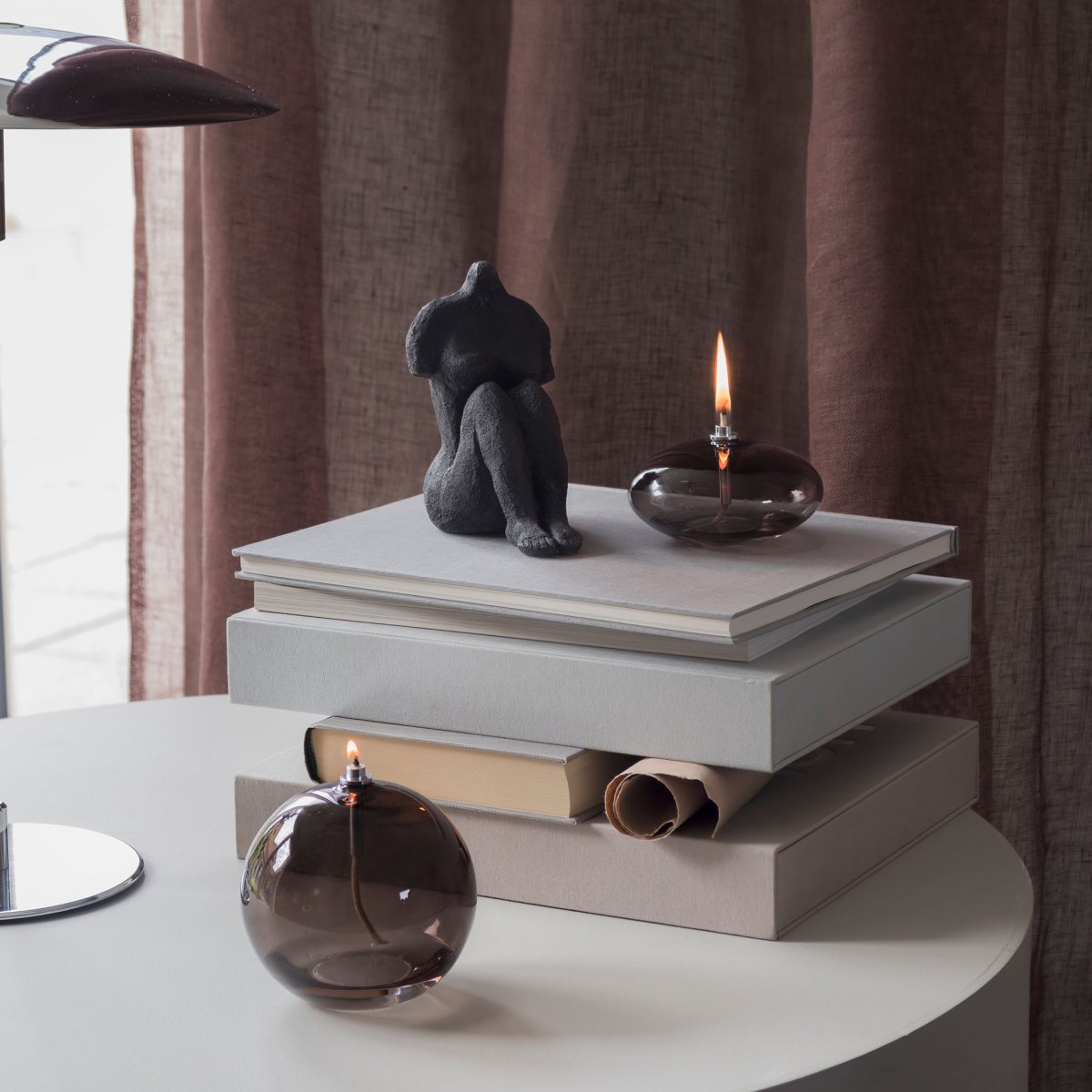 Öllampe Aura Klein Rauchfarben Von Mette Ditmer - Dess eleganta design och r&ouml;kf&auml;rgade glas sprider ett mjukt, varmt ljus som ger en lugn och mysig k&auml;nsla.