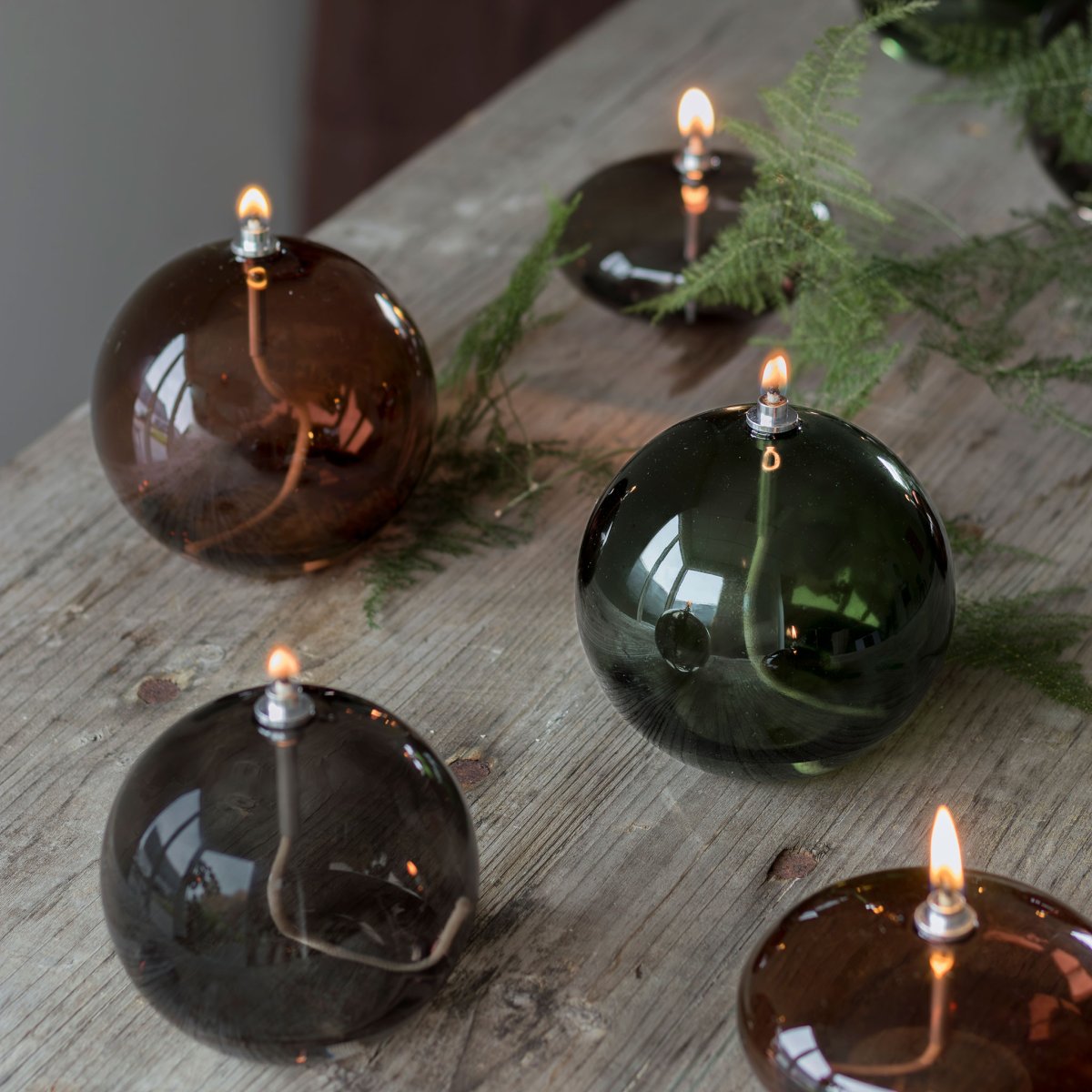 Öljylamppu Aura Mittel Rauchfarben Von Mette Ditmer - Dess eleganta design och r&ouml;kf&auml;rgade glas sprider ett mjukt, varmt ljus som ger en lugn och mysig k&auml;nsla.