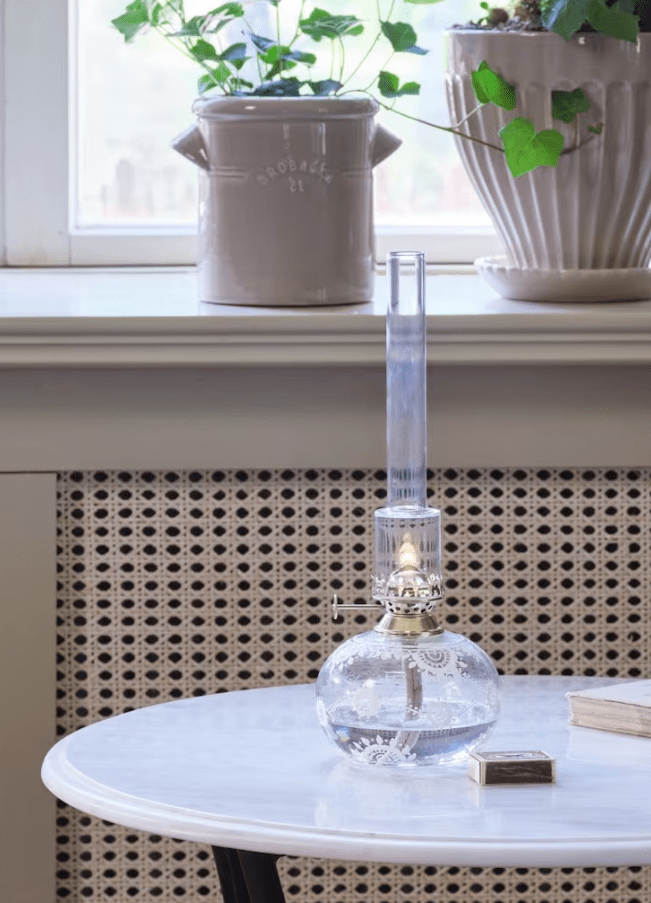 Kerosene lamp Oval Marja Transparent Von Strömshaga - Eine wundersch&ouml;ne runde Petroleumlampe aus Klarglas mit wundersch&ouml;nen wei&szlig;en handgefertigten Blumen, Messingbrenner und Klarglas-Brennerrohr.
