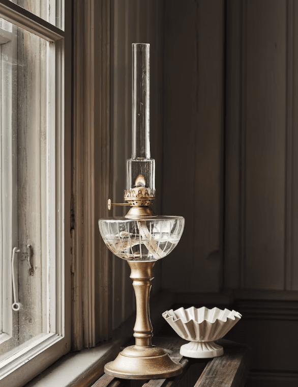 Kerosene table lamp Gold/Messing Von Strömshaga - Wunderbare Petroleumlampe an&aring; Sockel mit Brenner und Metallsockel mit antikem Messing-Finish, &Ouml;lgeh&auml;use aus klarem Glas mit ge&auml;tztem Muster.