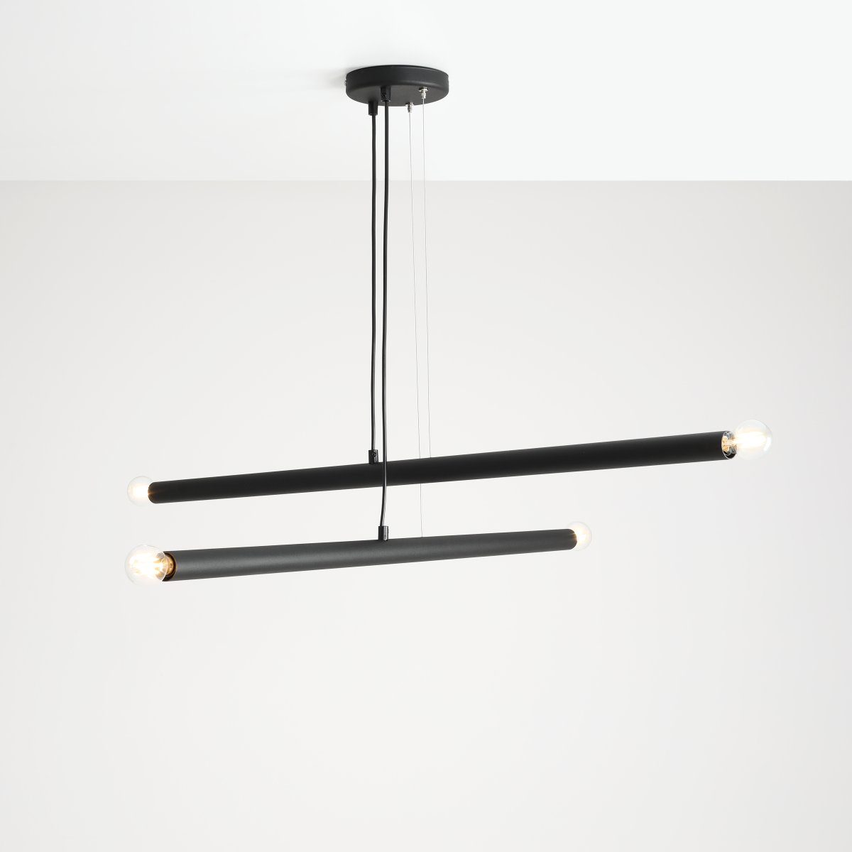 Tubo 4 100cm Schwarz hängelampe Von Artera - Sie besteht aus zwei schmalen Metallrohren in elegantem Schwarz, die in unterschiedlichen Winkeln angeordnet sind und so eine dynamische und luftige Optik erzeugen.