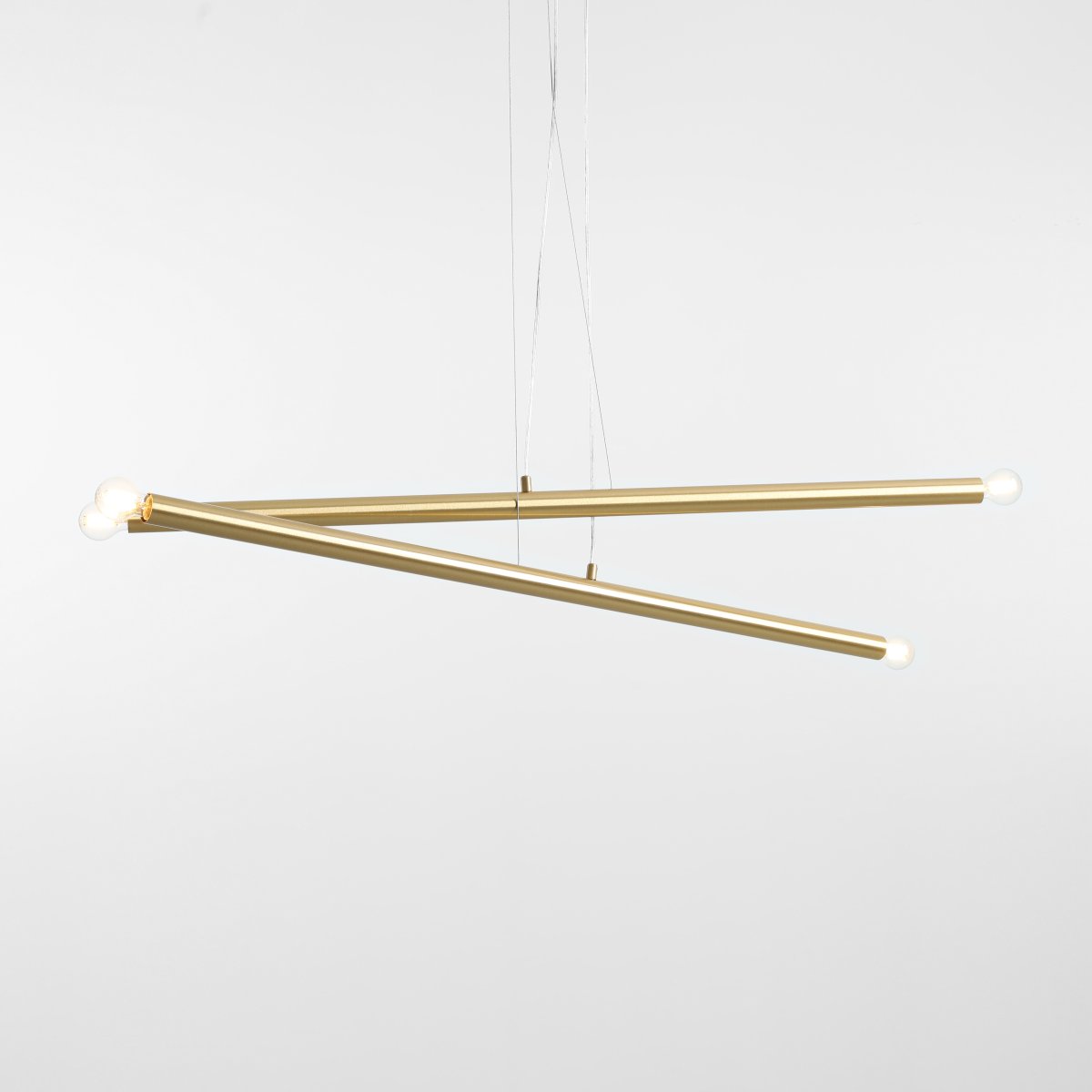 Tubo 4 100cm Messing hängelampe Von Artera - Die Leuchte besteht aus zwei schmalen Metallrohren in elegantem Messing-Finish, die in unterschiedlichen Winkeln angeordnet sind und so eine dynamische und luftige Optik erzeugen.