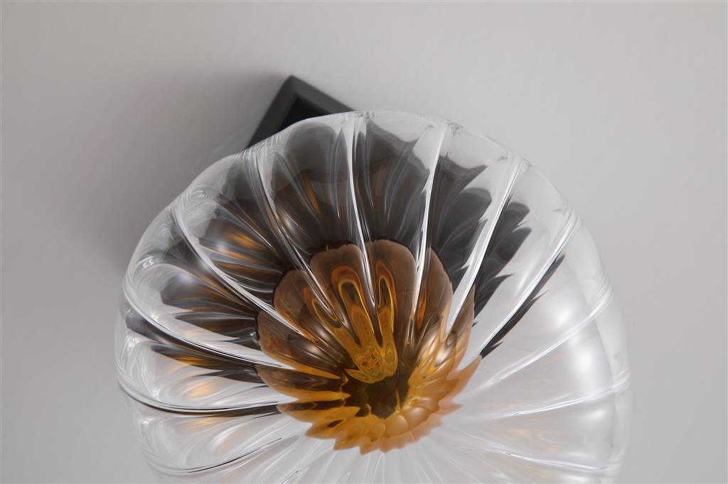 Sunbeam Ø14 Transparent/schwarz wandlampe Von Searchlight - Der runde, gerippte Schirm aus transparentem Glas beherbergt eine wunderschöne, bernsteinfarbene Kuppel, die dem Raum Struktur und Lebendigkeit verleiht und ihn gleichzeitig sanft und angenehm erhellt.