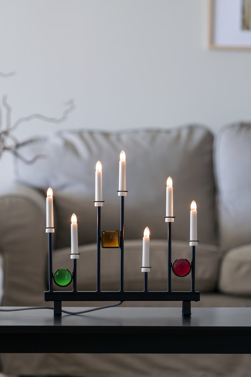 Candelabra 7 Lights Schwarz Von Konstsmide - Die sieben Kerzen werden von dekorativen farbigen Glasdetails in Gr&uuml;n, Rot und Bernstein eingerahmt und schaffen so eine elegante und festliche Atmosph&auml;re.