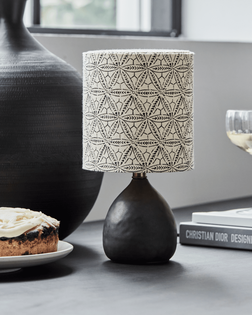 Flores 30cm Schwarz tischlampe Von House Doctor - Der Sockel aus schwarzer Steinzeugkeramik bietet eine stabile Grundlage, während der Lampenschirm aus Leinen mit einem handgedruckten Ethnomuster für einen einzigartigen Charakter sorgt.