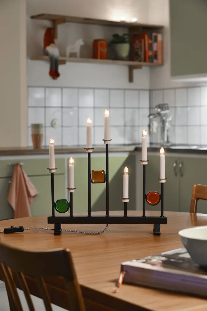 Candelabra 7 Lights Schwarz Von Konstsmide - Die sieben Kerzen werden von dekorativen farbigen Glasdetails in Gr&uuml;n, Rot und Bernstein eingerahmt und schaffen so eine elegante und festliche Atmosph&auml;re.