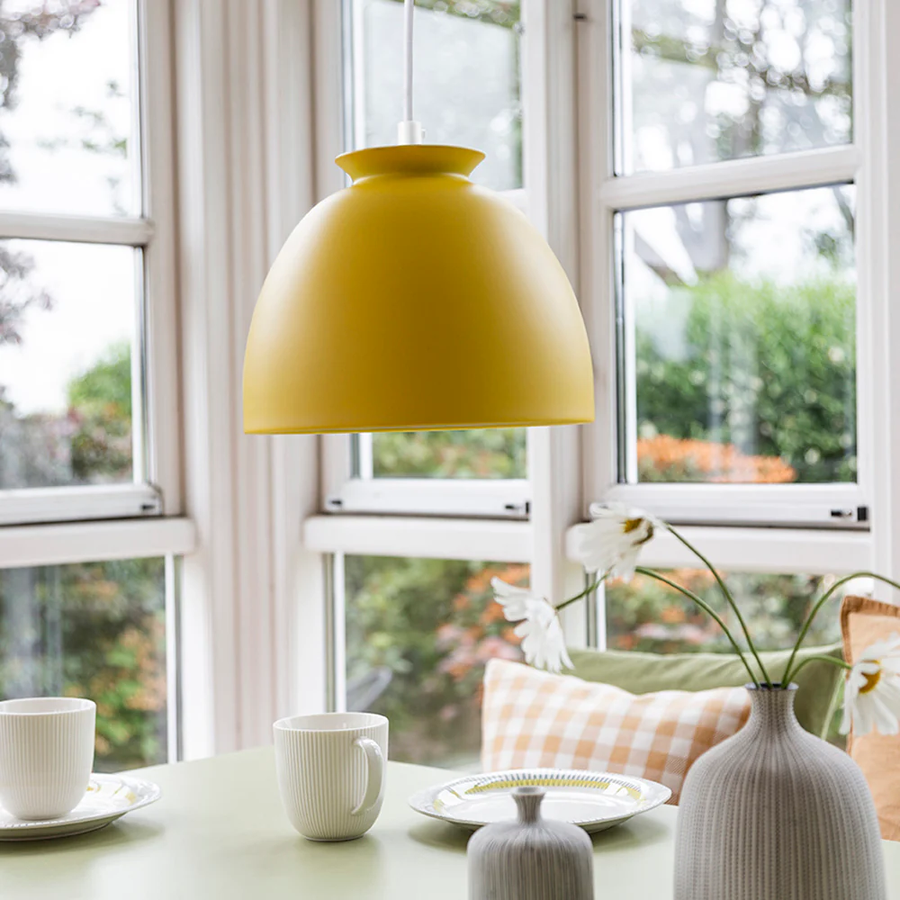 Bloom Ø23 Gelb hängelampe Von Superliving - Die Lampe hat ein mattgelbes Finish und ein weißes Textilkabel für ein elegantes Aussehen.