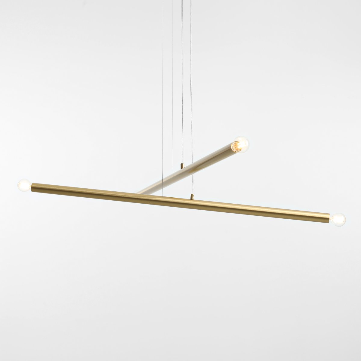 Tubo 4 100cm Messing hängelampe Von Artera - Die Leuchte besteht aus zwei schmalen Metallrohren in elegantem Messing-Finish, die in unterschiedlichen Winkeln angeordnet sind und so eine dynamische und luftige Optik erzeugen.