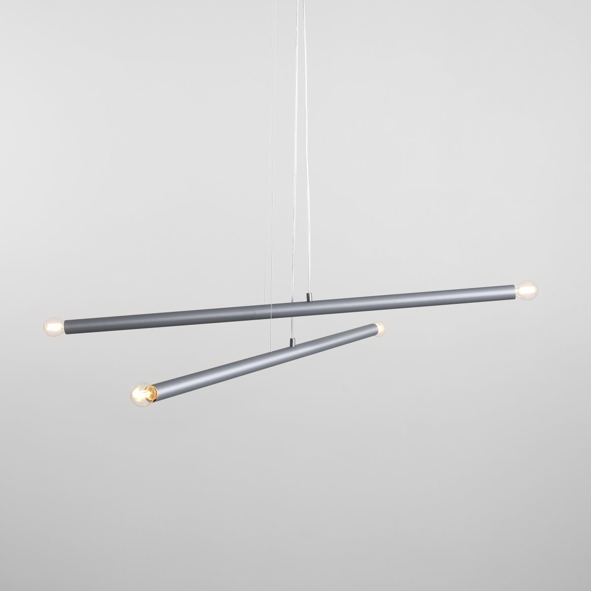 Tubo 4 100cm Stahl hängelampe Von Artera - Die Leuchte besteht aus zwei schmalen Metallrohren in elegantem Stahl-Finish, die in unterschiedlichen Winkeln angeordnet sind und so eine dynamische und luftige Optik erzeugen.