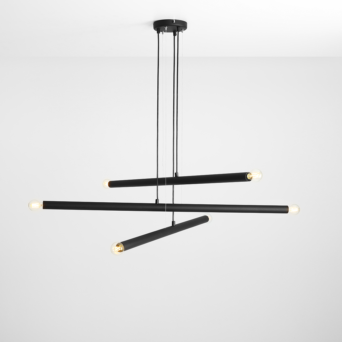 Tubo 6 100cm Schwarz hängelampe Von Artera - Sie besteht aus drei schmalen Metallröhren in elegantem Schwarz, die in unterschiedlichen Höhen und Winkeln angeordnet sind und so eine dynamische und luftige Optik erzeugen.