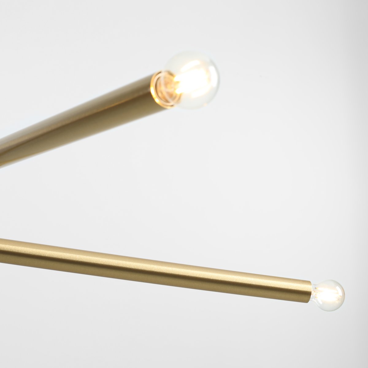 Tubo 4 100cm Messing hängelampe Von Artera - Die Leuchte besteht aus zwei schmalen Metallrohren in elegantem Messing-Finish, die in unterschiedlichen Winkeln angeordnet sind und so eine dynamische und luftige Optik erzeugen.