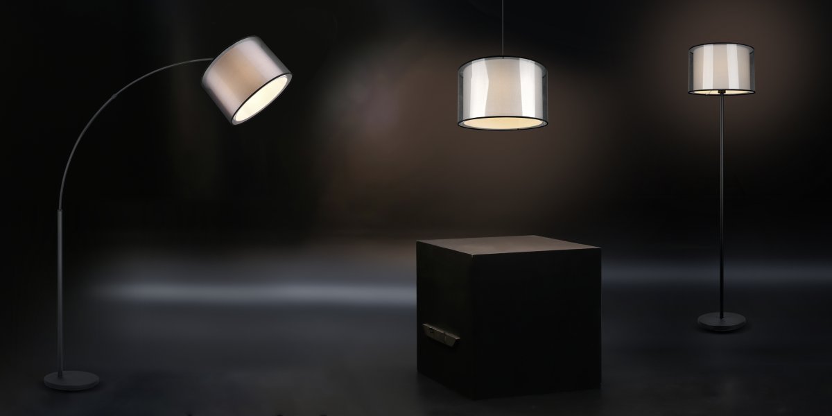 Burton Schwarz stehlampe Von Trio Lighting - Die moderne Kombination aus einem inneren weißen Stoffschirm und einem äußeren transparenten schwarzen Kunststoffschirm wirkt individuell und erfrischend zugleich und lässt sich in moderne Wohnwelten integrieren.