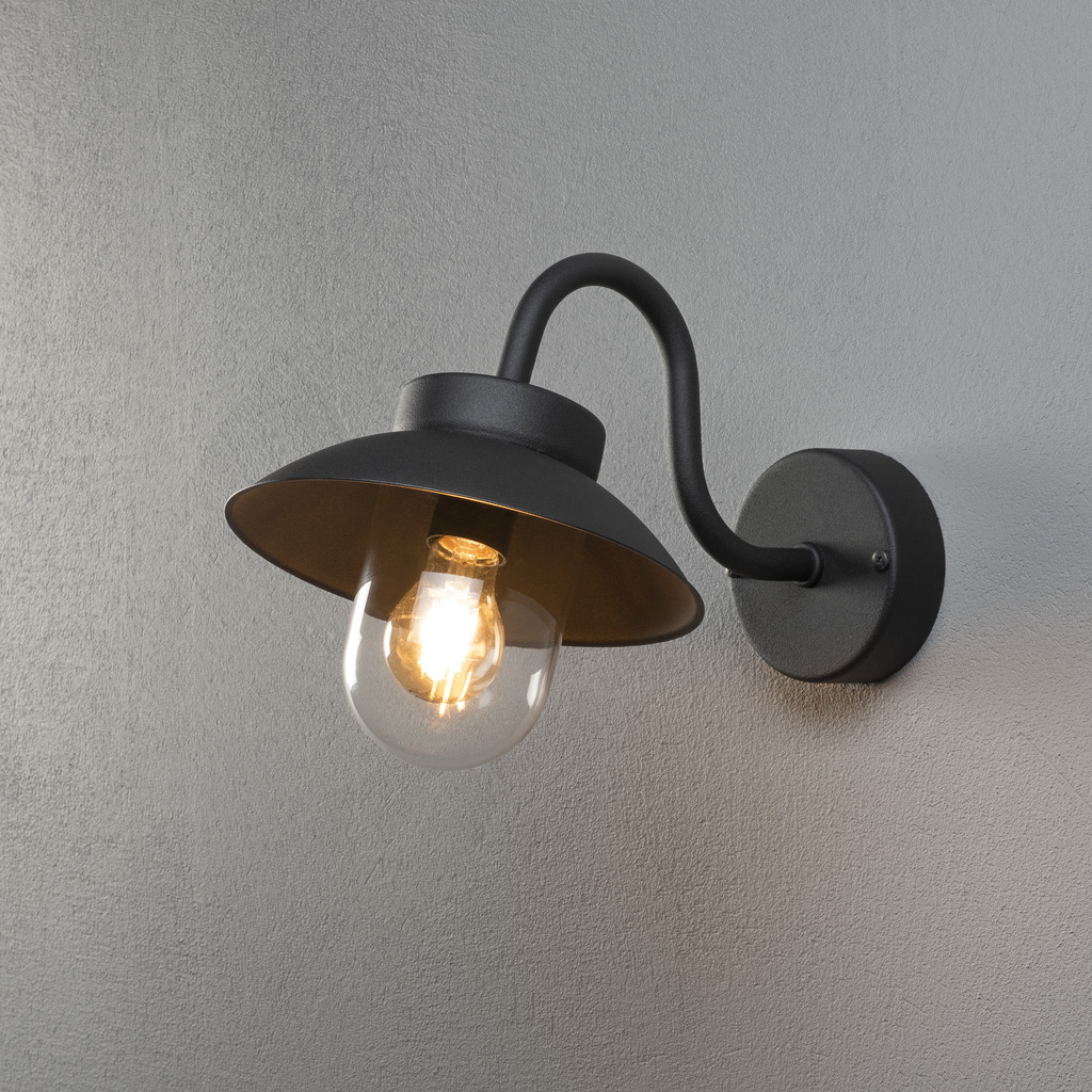 Vega Schwarz außenlampe Von Konstsmide - Der breite Schirm und die klare Glaskuppel verbreiten ein angenehmes und gerichtetes Licht, wodurch die Lampe perfekt für Eingänge und Terrassen geeignet ist.