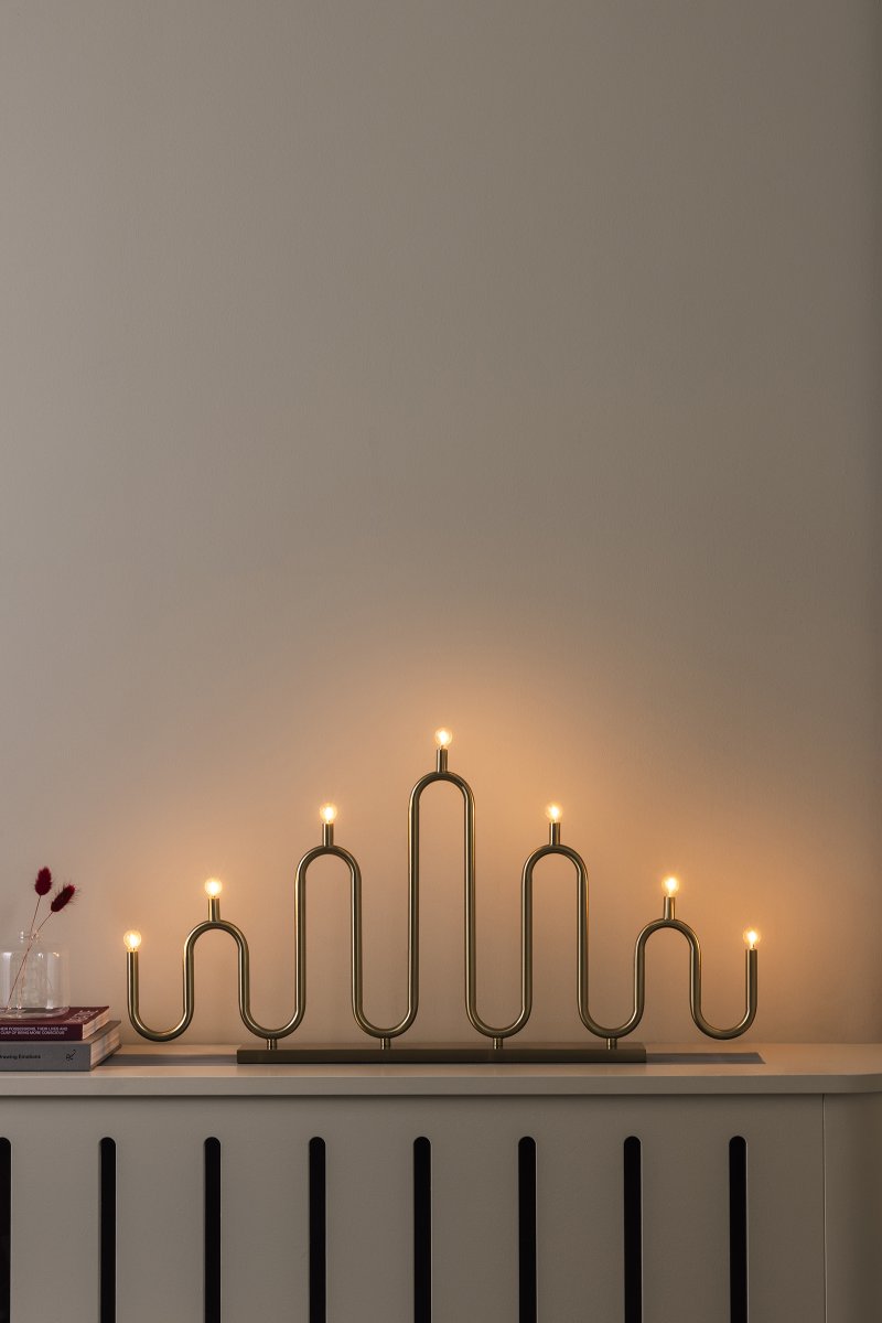 Noel 7 Messing Von Globen Lighting - Noel ist ein dekorativer Adventskerzenhalter aus Eisen mit einer eleganten Oberfläche aus gebürstetem Messing.