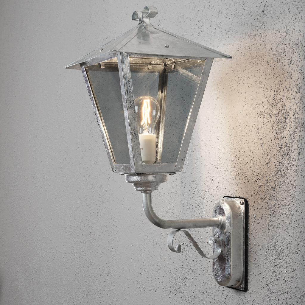 Benu Verzinkter Stahl außenlampe Von Konstsmide - Die klassische Laternenform und die robusten Materialien machen die Lampe zur perfekten Wahl f&uuml;r alle, die in Eingangsbereichen oder langen Fluren eine einladende Atmosph&auml;re schaffen m&ouml;chten.