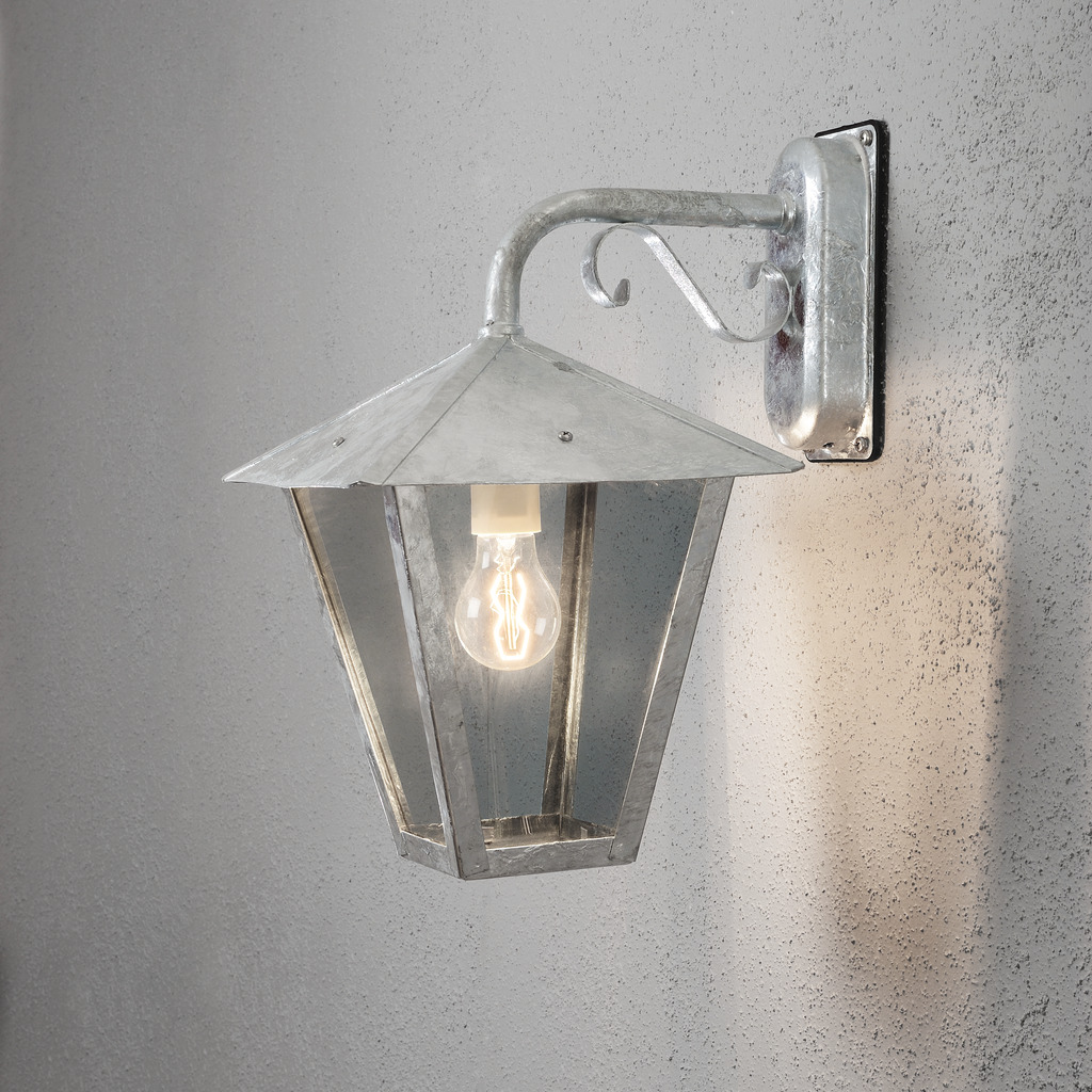 Benu Verzinkter Stahl außenlampe Von Konstsmide - Die klassische Laternenform und die robusten Materialien machen die Lampe zur perfekten Wahl f&uuml;r alle, die in Eingangsbereichen oder langen Fluren eine einladende Atmosph&auml;re schaffen m&ouml;chten.
