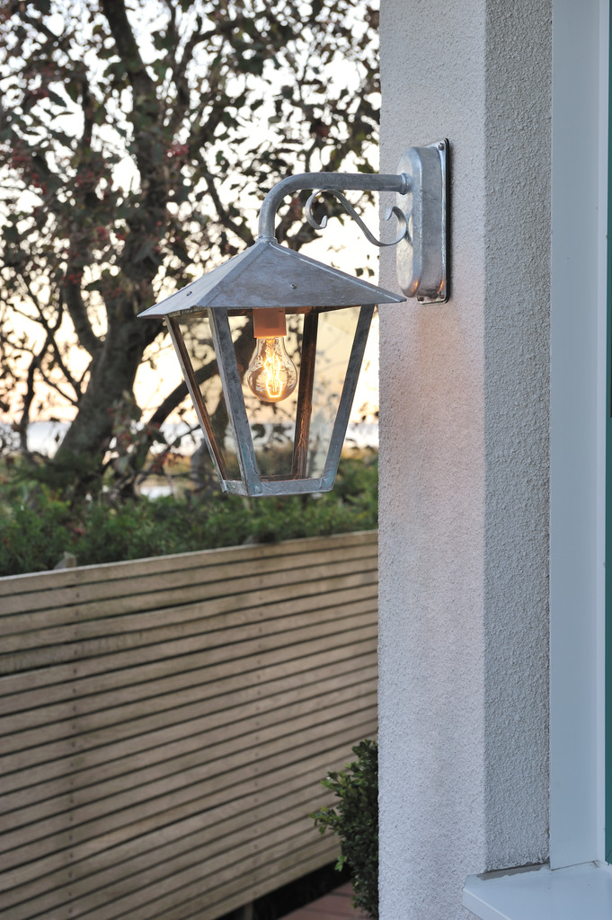 Benu Verzinkter Stahl außenlampe Von Konstsmide - Die klassische Laternenform und die robusten Materialien machen die Lampe zur perfekten Wahl f&uuml;r alle, die in Eingangsbereichen oder langen Fluren eine einladende Atmosph&auml;re schaffen m&ouml;chten.