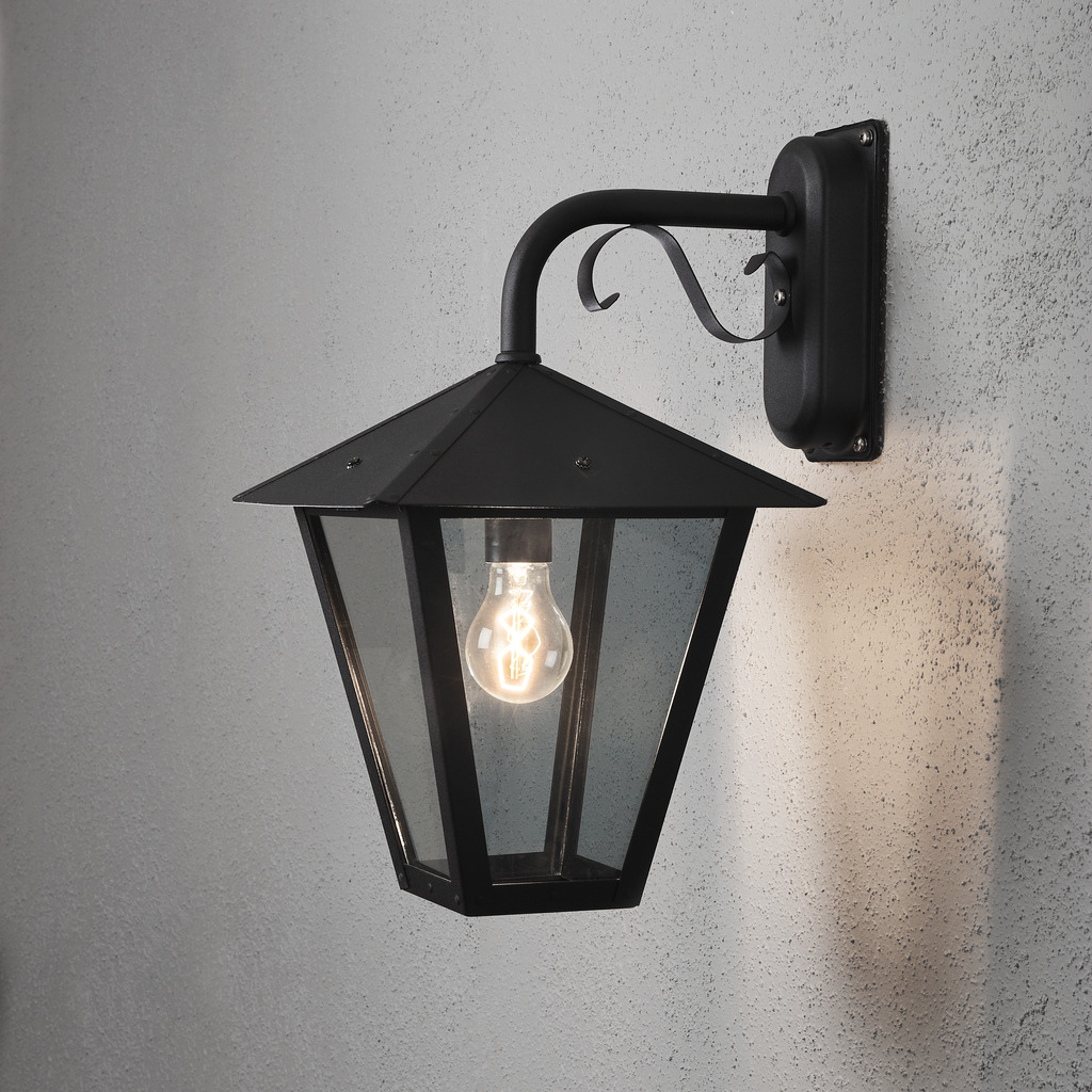 Benu Schwarz außenlampe Von Konstsmide - Die klassische Laternenform und die robusten Materialien machen die Lampe zur perfekten Wahl f&uuml;r alle, die in Eingangsbereichen oder langen Fluren eine einladende Atmosph&auml;re schaffen m&ouml;chten.
