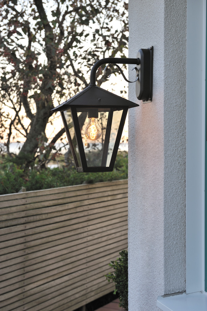 Benu Schwarz außenlampe Von Konstsmide - Die klassische Laternenform und die robusten Materialien machen die Lampe zur perfekten Wahl f&uuml;r alle, die in Eingangsbereichen oder langen Fluren eine einladende Atmosph&auml;re schaffen m&ouml;chten.