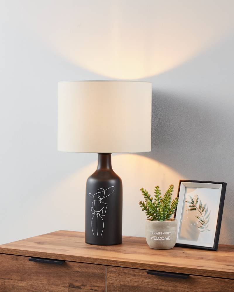 Vinoza 53cm Schwarz tischlampe Von Eglo - Mit einem schwarzen Sockel, der mit minimalistischen Linien verziert ist, die eine Frau mit Hut darstellen, verleiht die Lampe Ihrem Zuhause eine anspruchsvolle und künstlerische Note.