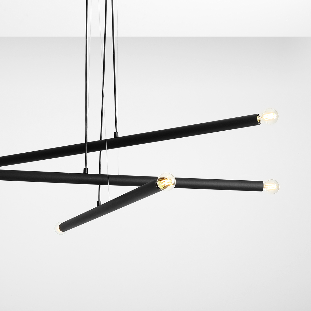 Tubo 6 100cm Schwarz hängelampe Von Artera - Sie besteht aus drei schmalen Metallröhren in elegantem Schwarz, die in unterschiedlichen Höhen und Winkeln angeordnet sind und so eine dynamische und luftige Optik erzeugen.
