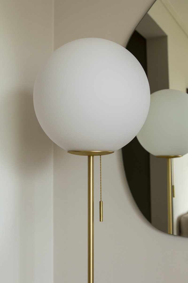 Torrano Beiger Travertin stehlampe Von Globen Lighting - Torrano hat einen Sockel aus wunderschönem, massivem Stein, Metalldetails und einen Glasschirm aus mattweißem Glas.