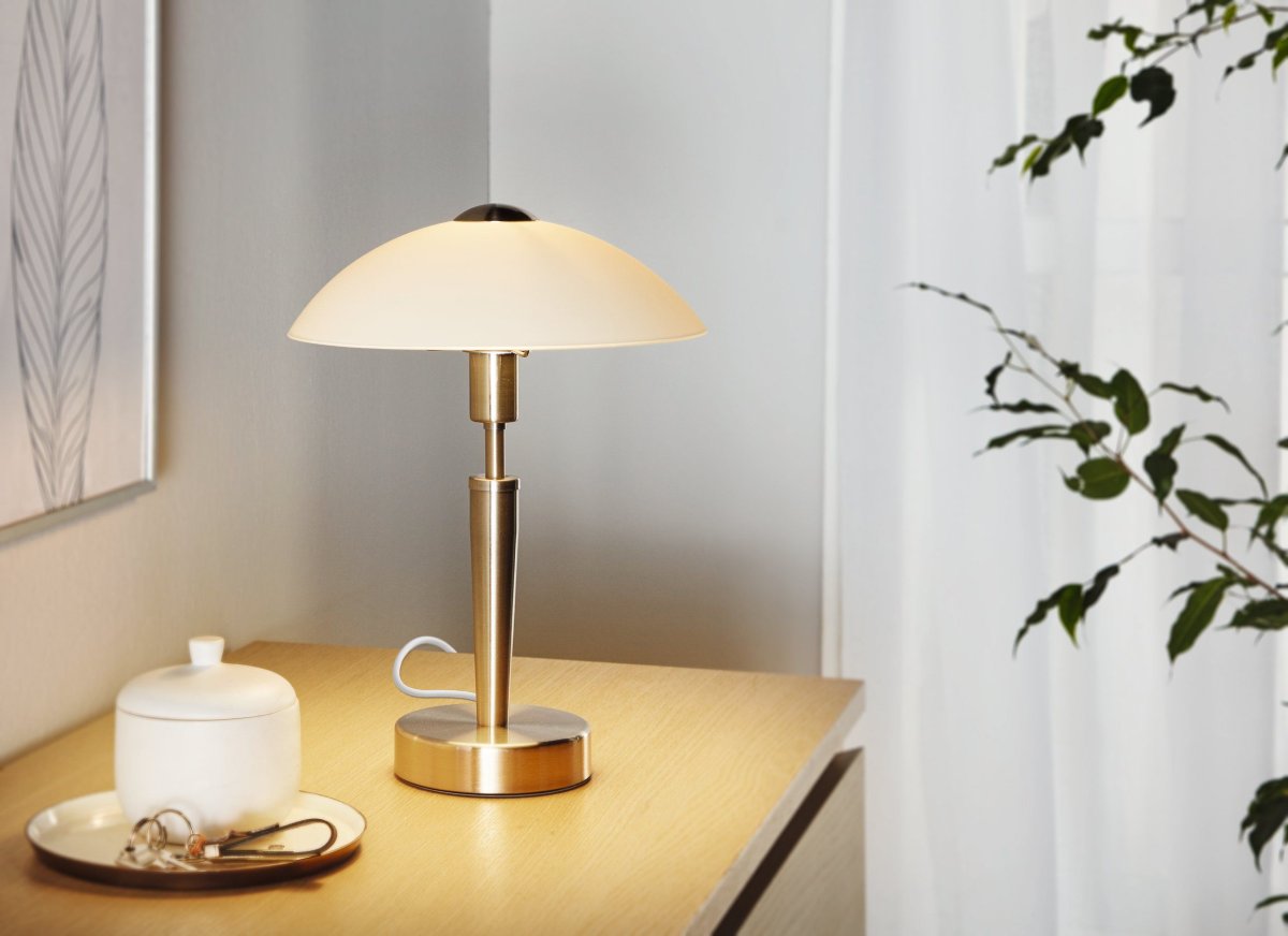 Solo 35cm Nickel tischlampe Von Eglo - Sie ist aus Metall gefertigt, mit einer eleganten, matten Nickeloberfl&auml;che, und verf&uuml;gt &uuml;ber einen satinierten Glasschirm, der ein sanftes und angenehmes Licht spendet.