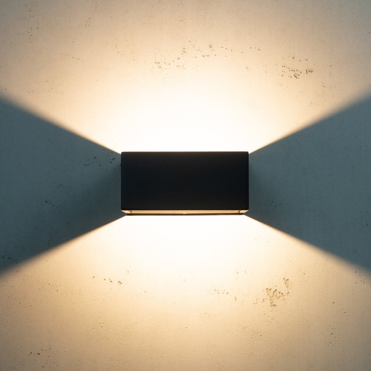 Jupiter Schwarz außenlampe Von Dyberg Larsen - Jupiter hat eine flache Seite an der Wand und eine halbrunde Vorderseite mit einer LED-Lichtquelle, die entlang der Wand auf und ab leuchtet.