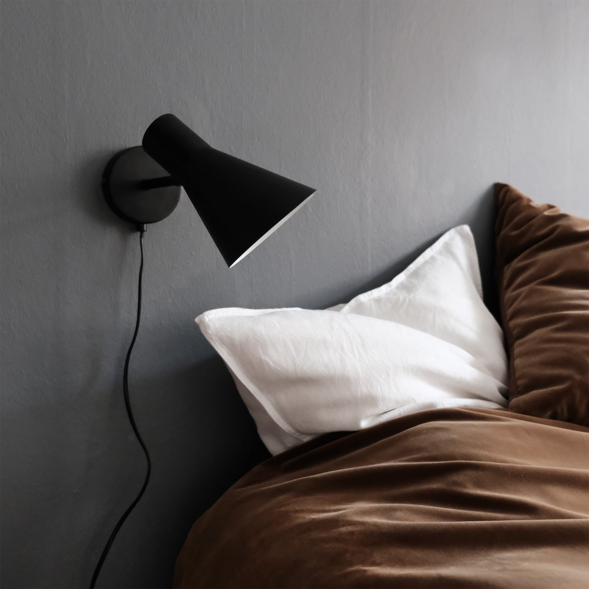 DL12 Schwarz leselampe Von Dyberg Larsen - Mit ihrem modernen, mattschwarzen Design und dem abgewinkelten Schirm sorgt die DL12 für ein fokussiertes und angenehmes Licht, ideal für Ecklampen oder als Nachttischlampe.