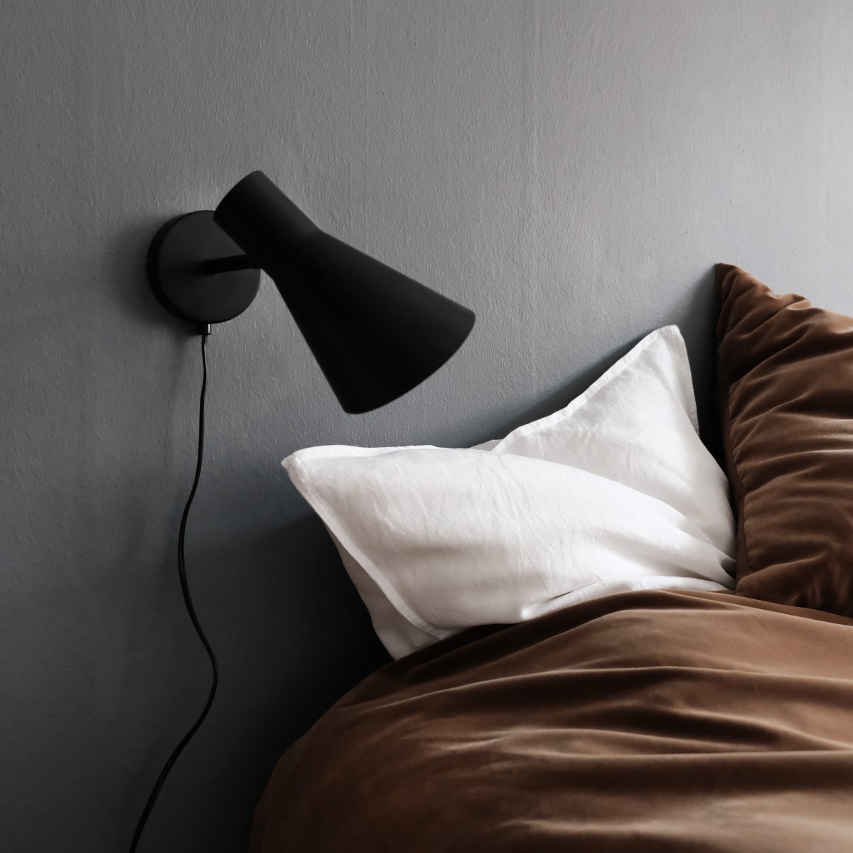 DL12 Schwarz leselampe Von Dyberg Larsen - Mit ihrem modernen, mattschwarzen Design und dem abgewinkelten Schirm sorgt die DL12 für ein fokussiertes und angenehmes Licht, ideal für Ecklampen oder als Nachttischlampe.