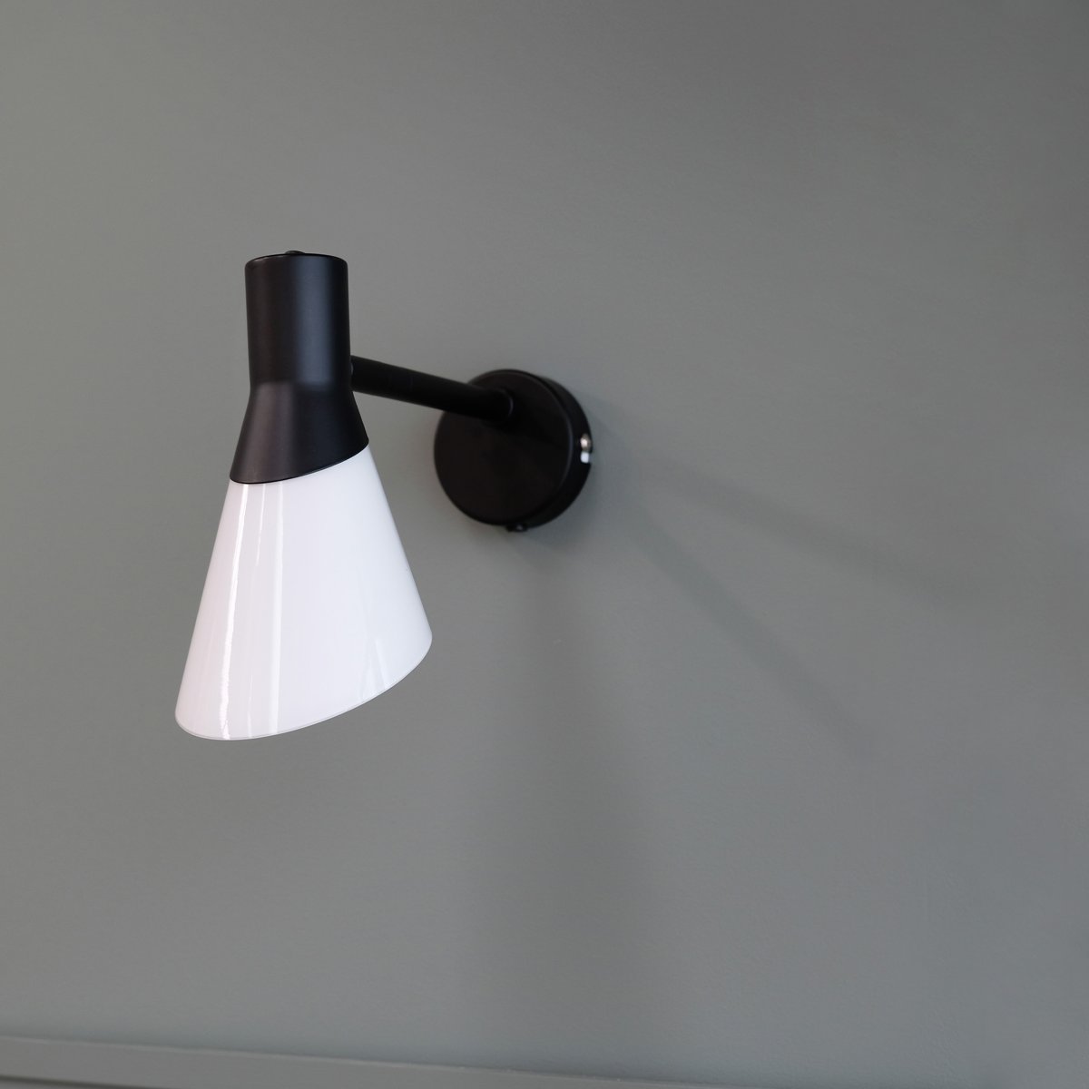 Gent 30cm Schwarz wandlampe Von Dyberg Larsen - Gent ist eine moderne und stilvolle Wandleuchte mit einem Lampenschirm aus Opalglas kombiniert mit schwarzem Metall.