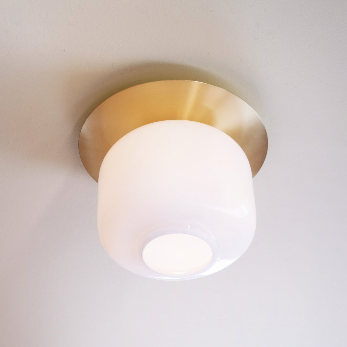 Arp Ø25 Messing deckenleuchte Von Dyberg Larsen - Die Leuchte sitzt dicht an der Decke und die messingfarbene Platte schafft einen eleganten Übergang zwischen Decke und Glas.