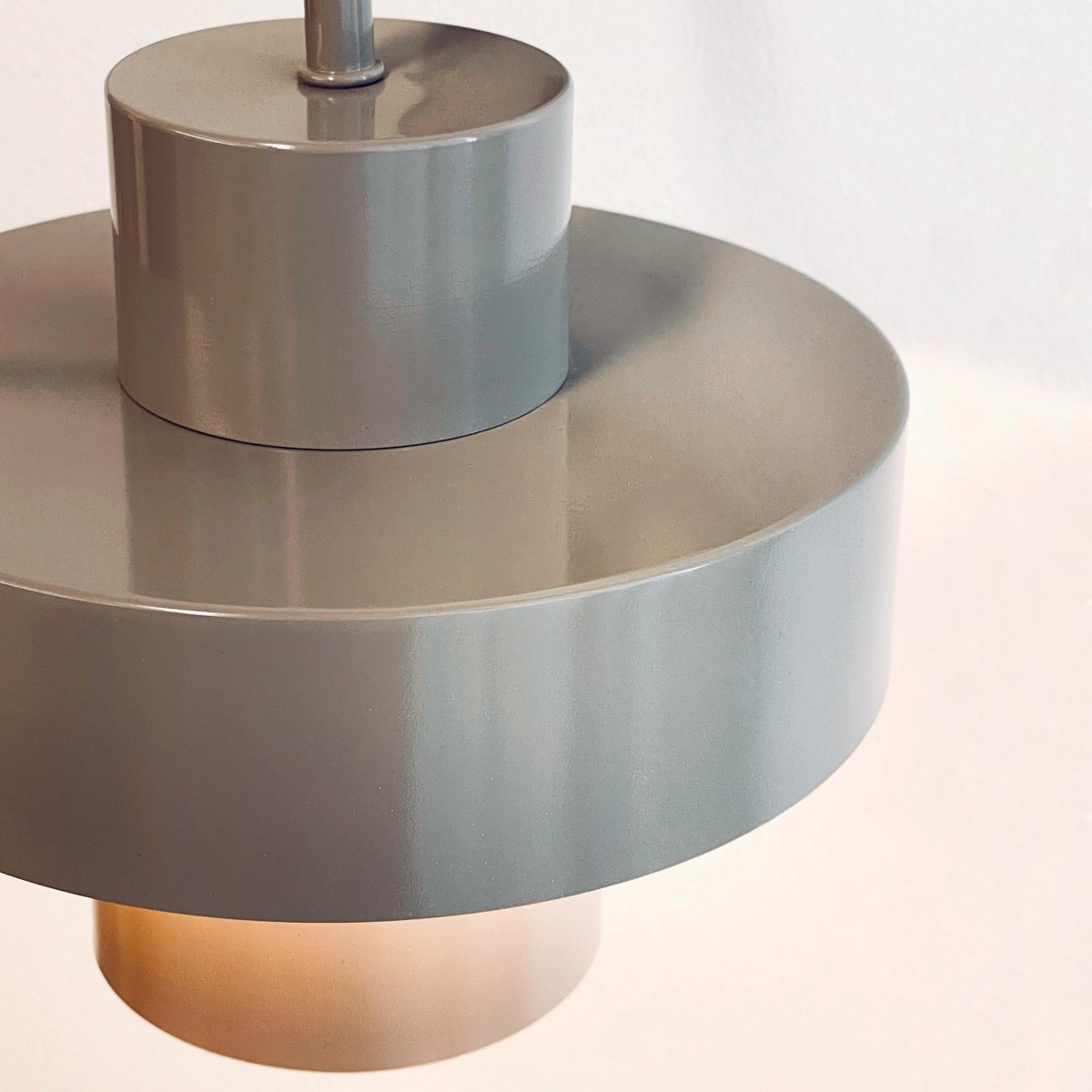 Stoke Ø15 Warmes Grau wandlampe Von Dyberg Larsen - Sie besteht aus Metall mit einer glänzenden Oberfläche, die die zylindrischen Formen der Lampe hervorhebt und einen ausgewogenen Kontrast zu anderen Materialien wie Stein, Holz und Glas bildet.