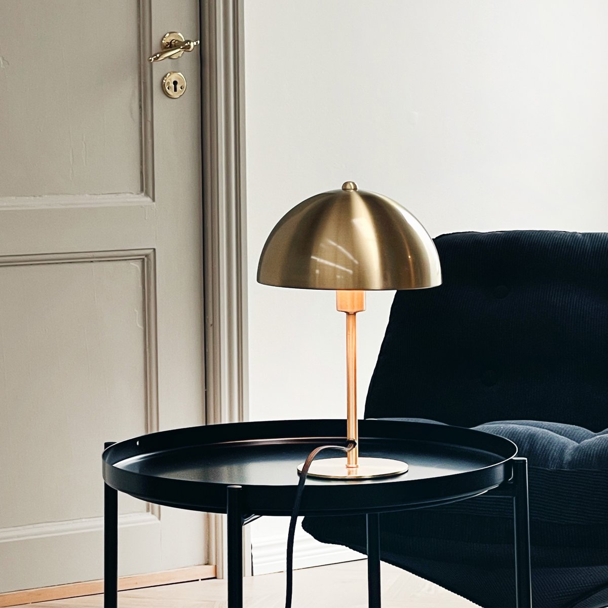 Lyon 30cm Messing tischlampe Von Dyberg Larsen - Der halbrunde Schirm verleiht einen modernen Touch und sorgt für eine angenehme und gleichmäßige Lichtverteilung, ideal sowohl für die Arbeits- als auch für die Stimmungsbeleuchtung.