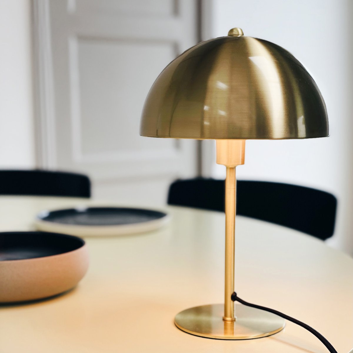 Lyon 30cm Messing tischlampe Von Dyberg Larsen - Der halbrunde Schirm verleiht einen modernen Touch und sorgt für eine angenehme und gleichmäßige Lichtverteilung, ideal sowohl für die Arbeits- als auch für die Stimmungsbeleuchtung.