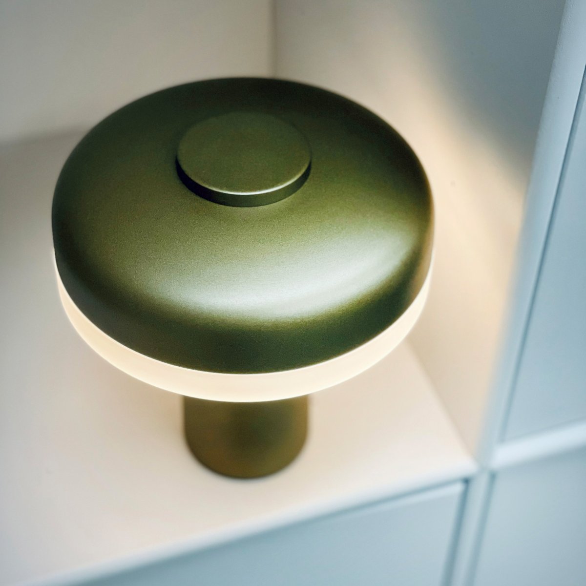 Porter 16cm Metallic-Grün tragbare Von Dyberg Larsen - Die wiederaufladbare LED-Tischleuchte Porter ist eine moderne und funktionale Leuchte mit einzigartigem Design, bei dem das Licht vom Rand kommt und so für ein angenehmes und gleichmäßiges Licht sorgt.